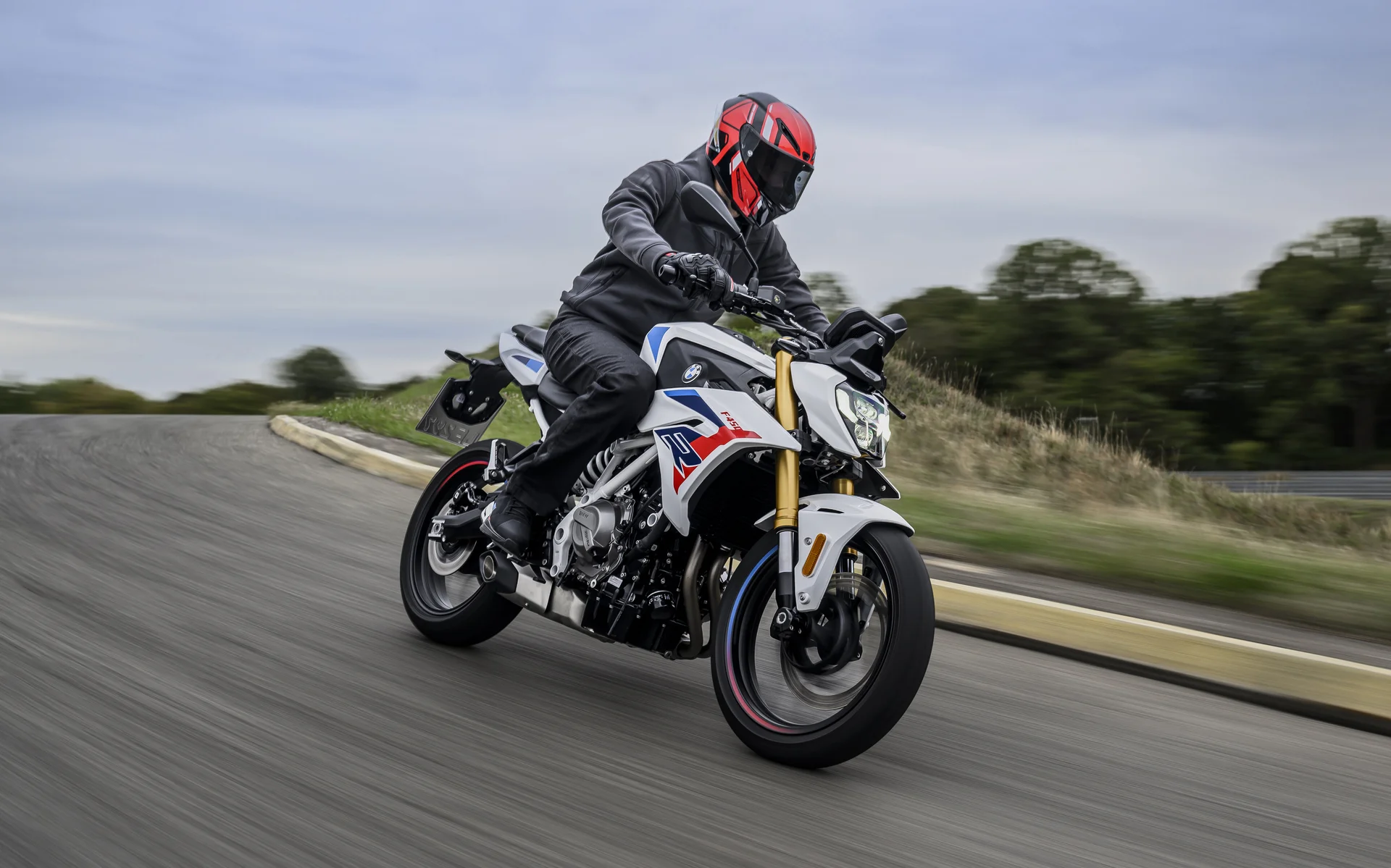 Piloto sobre a BMW F 450 R 2027 em movimento — posição de pilotagem ereta